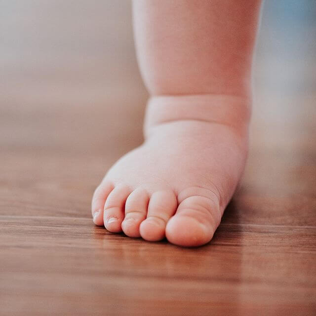 Piede bambino su parquet in legno